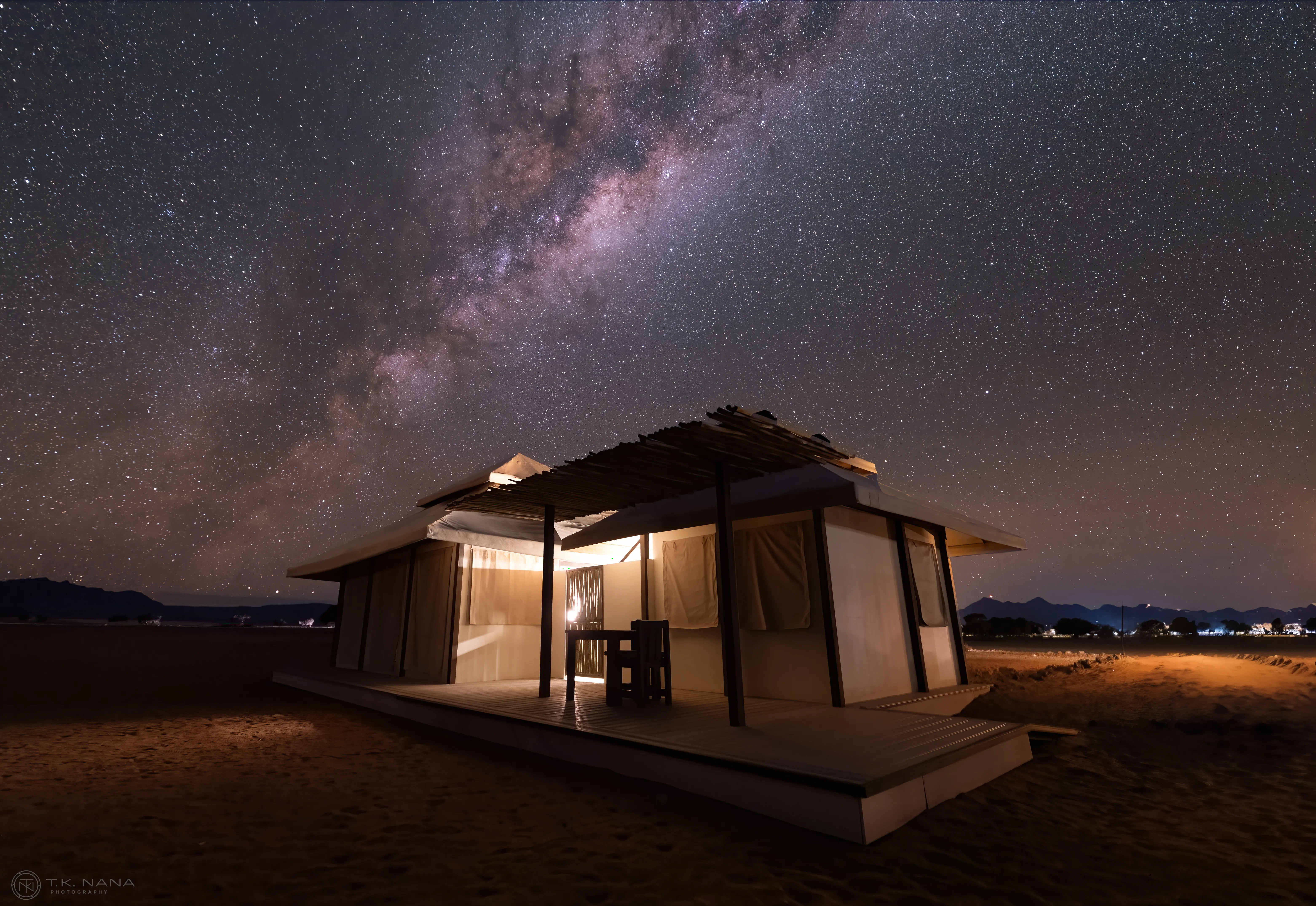 A dune of sand piled against a lamp-lit wall inside a house